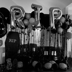 black and white photograph of balloons that spell out the word r i p n d