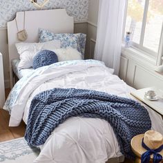 a bed with blue and white decor in a bedroom