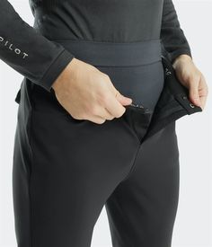 a person is holding their pocket open to show the zippers on his black pants