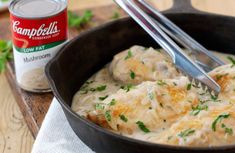 a skillet filled with chicken and gravy next to a can of campbell's soup