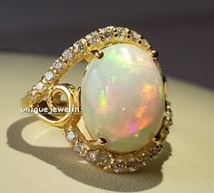 an opalite and diamond ring is shown on a white surface with gold trimmings