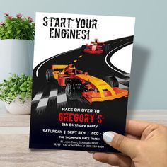 a hand holding up a race car birthday party card