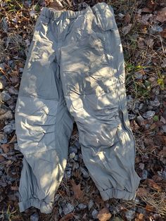 Genuine U.S army issue extreme cold weather thermal pants. They are part of the ECWS (Extreme Cold Weather System). They are constructed with a water resistant outer shell and PrimaLoft Sport thermal bonded high-loft insulation on the inside. They have full-length side-zipper openings, and a zippered fly opening and an elastic waist. These are used but in great shape and ready to keep you warm all winter! Designed to be basically moisture impermeable, windproof, breathable and long lasting and a Military Nylon Outdoor Pants, Combat Style Cargo Pants For Outdoor, Combat Style Full Length Cargo Pants For Outdoor, Gray Techwear Pants For Outdoor Activities, Techwear Gray Bottoms For Outdoor Activities, Camouflage Techwear Bottoms For Outdoor Activities, Practical Khaki Cargo Pants For Outdoor, Techwear Camouflage Bottoms For Outdoor Activities, Gray Techwear Pants For Outdoor