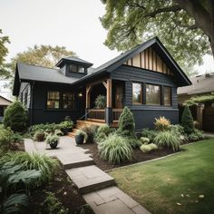 a blue house with lots of plants in front of it and steps leading up to the porch