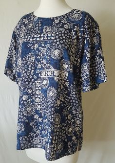 "Awesome Batik Floral Top from the 80's by Norton McNaughton Short Sleeved Padded Shoulders Unique Pattern You'll be the only one in town with a shirt this hip Size 12 (see measurements below) Armpit to armpit: 20\" Total length: 27\" Shoulder to shoulder: 21\" EXCELLENT CONDITION Free Shipping. Save at least $4.50" Vintage Patterned Beach Tops, Vintage Patterned Tops For Beach, Vintage Printed Tops For Festival, Vintage Patterned Printed Tops, Vintage Relaxed Fit Top With All Over Print, Vintage Patterned Top With All Over Print, Vintage Patterned Tops With All Over Print, Casual Blue Batik Print Top, Vintage Paisley Print Summer Tops