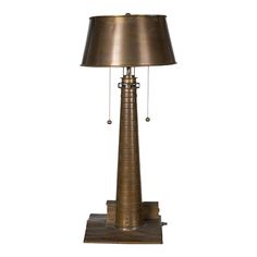 a lamp that is sitting on top of a wooden base with a metal shade over it