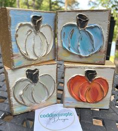 four painted pumpkins are sitting on a table