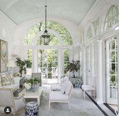 a living room filled with furniture and lots of windows covered in white paint on the walls