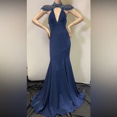 a mannequin wearing a blue dress with an open back and beaded neckline