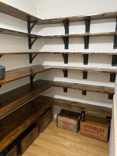 an empty room with shelves and boxes on the floor