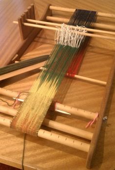 the loom is being worked on by someone using two different types of yarns