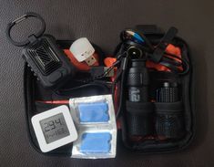 the contents of an emergency kit are neatly packed in a pouch on a table top