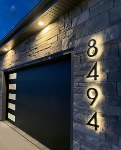 a garage door with the numbers on it and lights in front of it at night