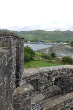 an old stone wall overlooking a body of water