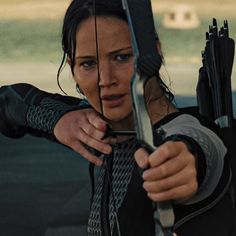 the woman is aiming her bow at something