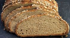 a loaf of whole wheat bread sitting on top of a black counter next to a knife