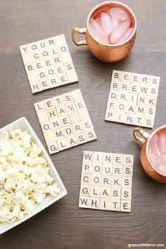 three cups of tea, two bowls of popcorn and some scrabble tiles on a table