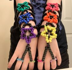 two hands with bracelets made out of beads