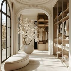 a white vase filled with flowers sitting on top of a table next to a walk in closet