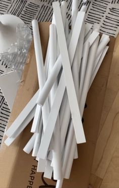 several white sticks sitting on top of a cardboard box