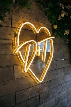 a heart shaped neon sign mounted to the side of a brick wall