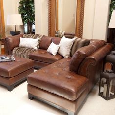 a living room filled with lots of brown furniture