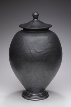 a large black vase sitting on top of a table