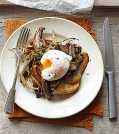 a white plate topped with an egg and mushrooms