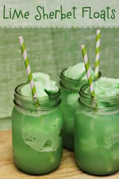 two mason jars filled with lime sherbet floats and striped straws in them