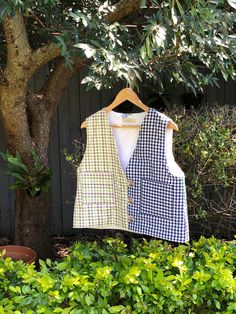 Handmade to love and to last. Completely unique and one of its kind. This unique fully lined vest is carefully and lovingly made by me, in my Sydney studio.  It is hand quilted, with a middle inner layer of 100% recycled cotton batting. Outer layer is 100% cotton multi coloured gingham - one side is a colourful purple/green/beige combination, the other a classic navy blue and white gingham. The lining is upcycled out of a thrifted white cotton table cloth that has the sweetest floral embroidery sewn at random. Button and loop closure gives it that vintage feel.  Best fit for a size S - M/L. This vest is a wider fit. Shoulder seam to bottom hem is approx  51 cm (20 inches). Perfect for layering in the cooler months, and as a statement outer piece in the warmer months. Fitted Plaid Cotton Vest, Gingham Vest, Gingham Quilt, Blue And White Gingham, Green Beige, Sweet Floral, Quilted Vest, Vest Outfits, Bright Stars