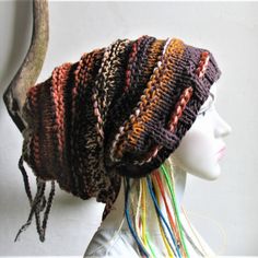 a knitted hat on top of a mannequin head with multicolored hair