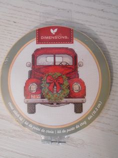 a cross - stitch picture of a red car with a wreath on it