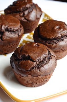 four chocolate muffins on a white plate