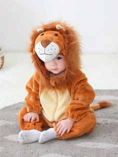 a baby in a lion costume sitting on the floor