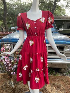 "Embroidered flower design with elastic waist, three front button, elastic cuff sleeve, tie back dress.  Full length is 43\" long ( 109 cm) One size. Suitable for dress sizes S-L ( US 2,4,6 & 8) Made of Soft Linen fabric  Perfect for Spring and Summer Model is 5'8 (152.4 cm)  Model Body Measurements: Bust. 34\" (86 cm) Waist 24'' (61 cm) Hips 36'' (91 cm) Made in Thailand" Casual Cotton Floral Midi Dress, Casual Cotton Midi Floral Dress, Casual Midi Dress With Floral Embroidery For Daywear, Casual Knee-length Floral Dress For Daywear, Casual Cotton Floral Knee-length Dress, Casual Cotton Knee-length Floral Dress, Casual Knee-length Cotton Floral Dress, Casual Cotton Floral Dress With Square Neck, Casual Mid-length Floral Dress For Daywear