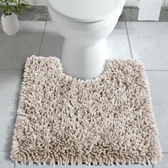 a white toilet sitting on top of a bathroom floor next to a rug covered in dirt