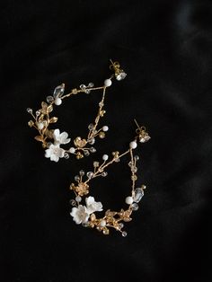 two pieces of jewelry sitting on top of a black cloth