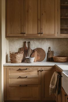 a kitchen with wooden cabinets and white counter tops, including cutting boards on the counters