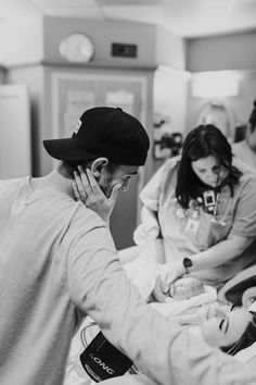 a black and white photo of two nurses tending to a baby