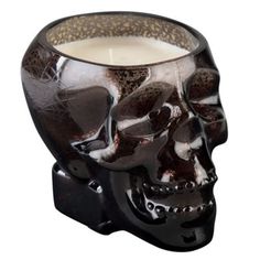 a candle holder with a skull on it's face and the candle is lit