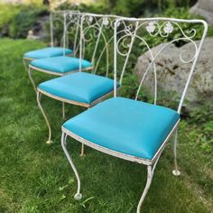 three blue chairs sitting on top of green grass