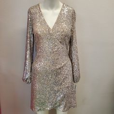 Brand New With Tags! Dress Has An Champagne Color Underlay With Silver Sequins On Top. It's A Wrap Dress That Has A Tie That Runs Through A Hole On One Side Of Waist To Secure It And Then Ties In Back. Has A Hook Eye Closure At Bust For Extra Coverage And Security! This Gorgeous Dress Is A Show Stopper For Sure! Be Ready To Be A Star In This! Glamorous V-neck Mini Dress For Holiday, Spring Dress With Sequins And Surplice Neckline, Glamorous Fitted Dress With Surplice Neckline, Glamorous Fitted Sequin Dress For Holidays, Glamorous Fitted Mini Dress For Holiday, Fitted Sequin Dress For Spring Holiday, Sequin Wrap Dress, Champagne Color, Gianni Bini