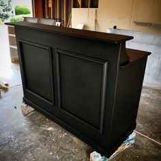 a black bar sitting in the middle of a room next to a pile of boxes