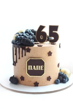 a birthday cake with berries, blueberries and chocolate frosting on top is decorated with the number 65