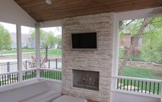 a living room filled with furniture and a flat screen tv mounted on the wall above a fireplace