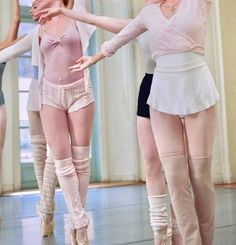 three ballerinas in white and pink are dancing