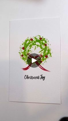 a christmas card with an ornament on it and a bow around the wreath