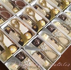 many different types of chocolates in boxes on a table with ribbons and tags attached to them