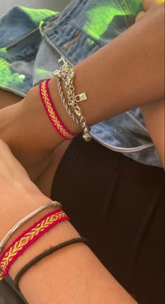 two people wearing bracelets sitting next to each other