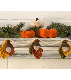 crocheted pumpkins and acorns hanging from a mantel